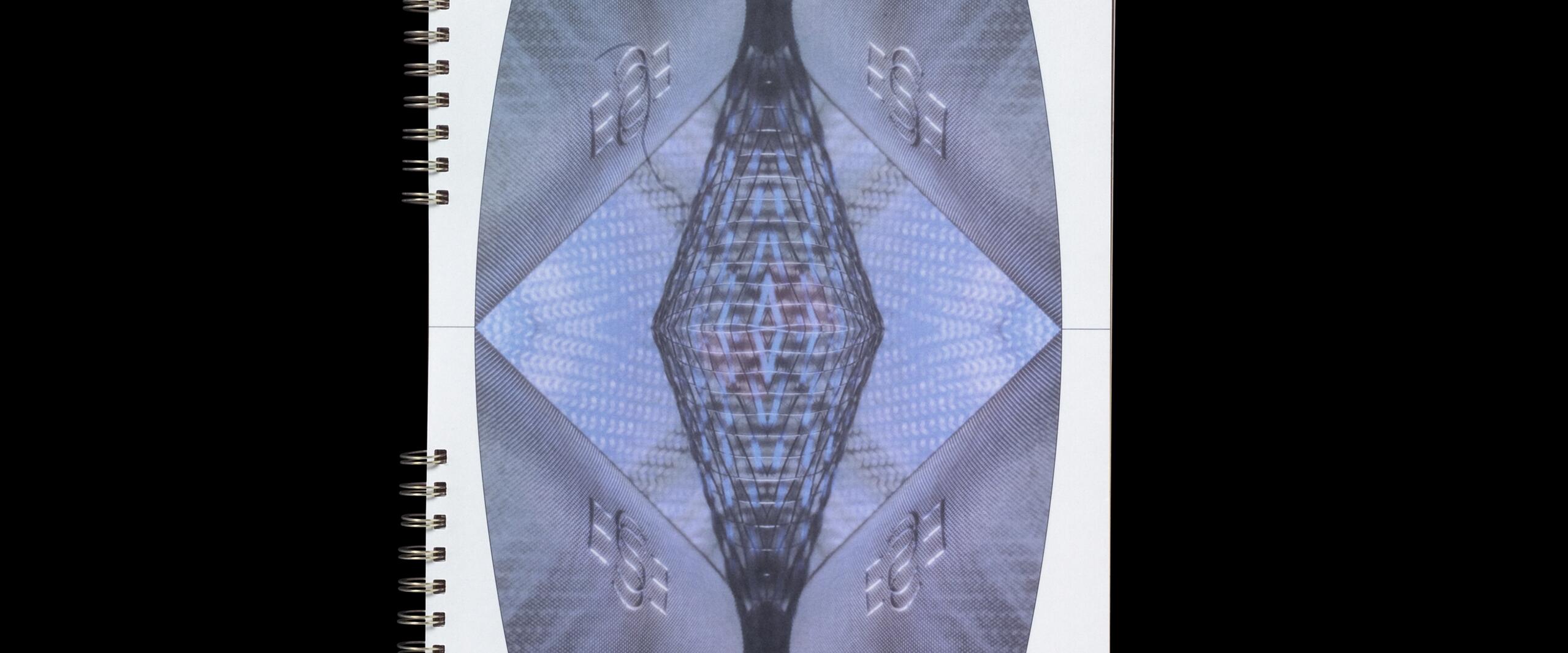 Abstract design on a spiral-bound notebook, featuring a mirrored geometric pattern with blue and gray hues.