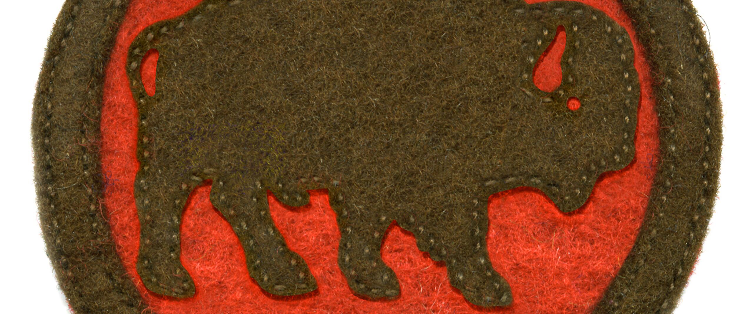 Brown bison silhouette on a red circular felt patch, bordered with a brown edge.