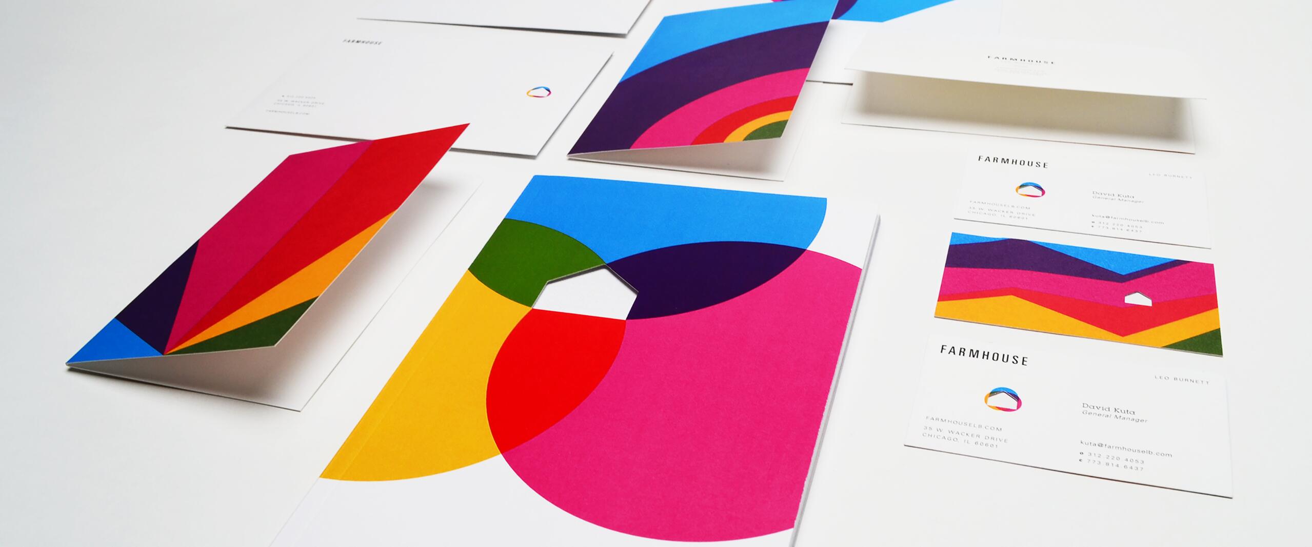 Colorful stationery set with geometric designs, including envelopes, business cards, and a letterhead. Dominant colors are pink, blue, yellow, and green. Each item features a modern and vibrant style.