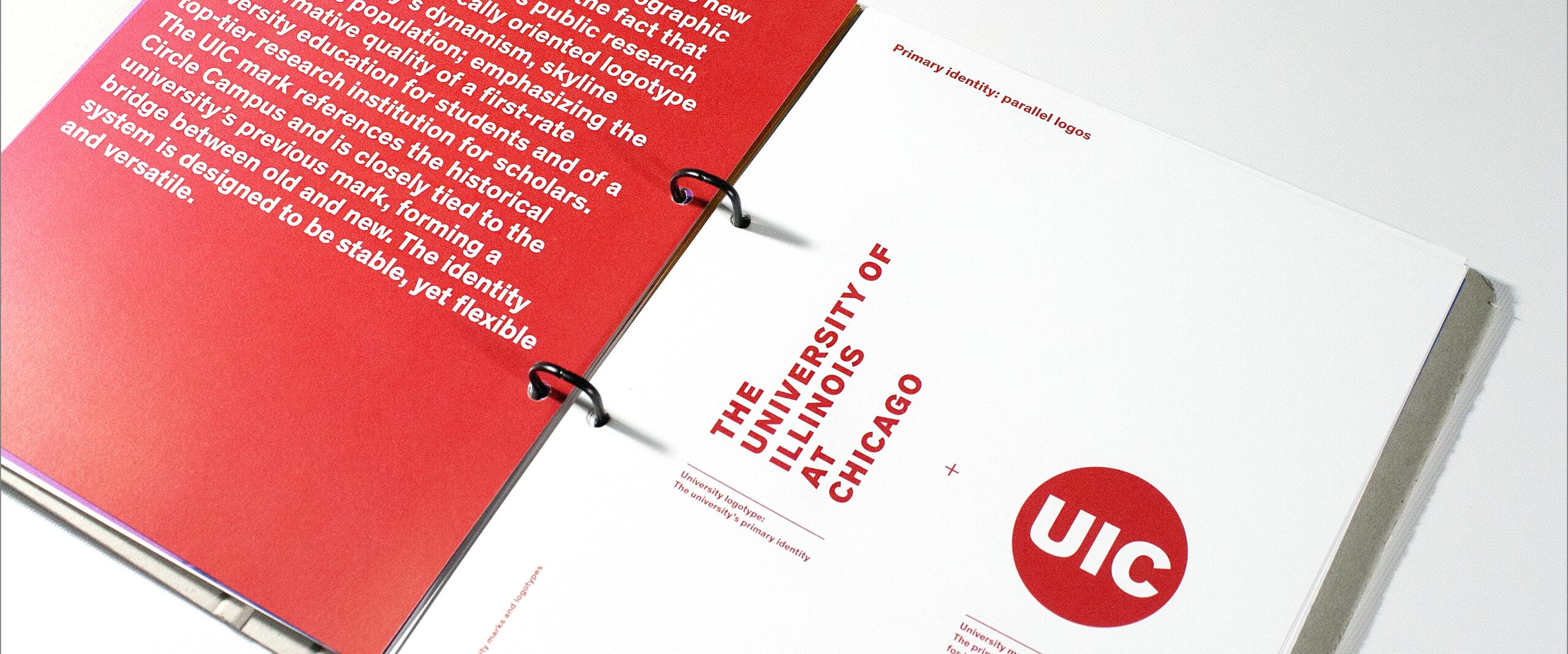 Open design booklet with red and white pages, featuring text about the University of Illinois at Chicago's identity and logo. Red circle with "UIC" on the right page, bold red text and black binder rings are visible.